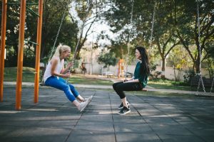 image of two girls on a swing